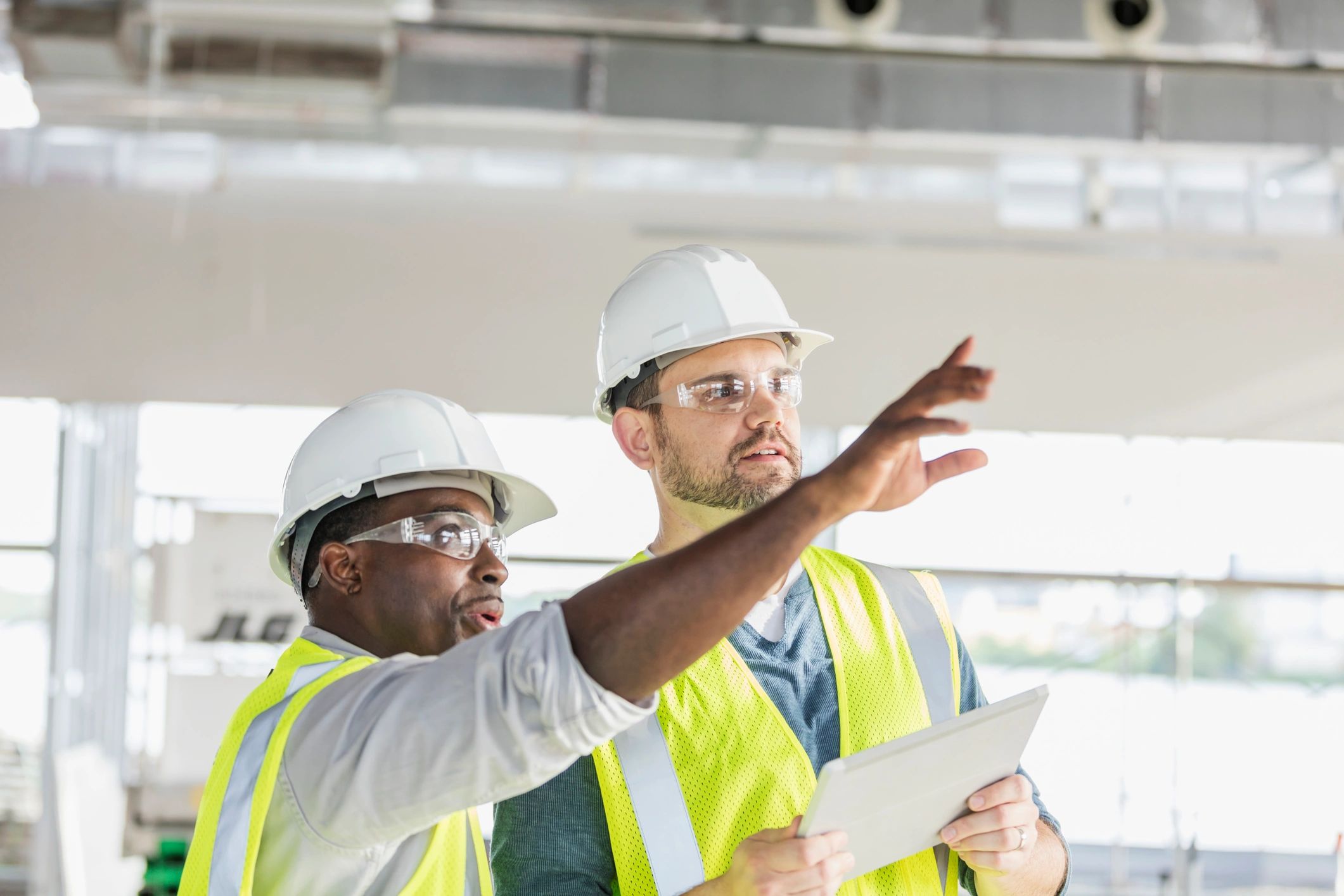 Project manager and field lead reviewing scope on a construction site
