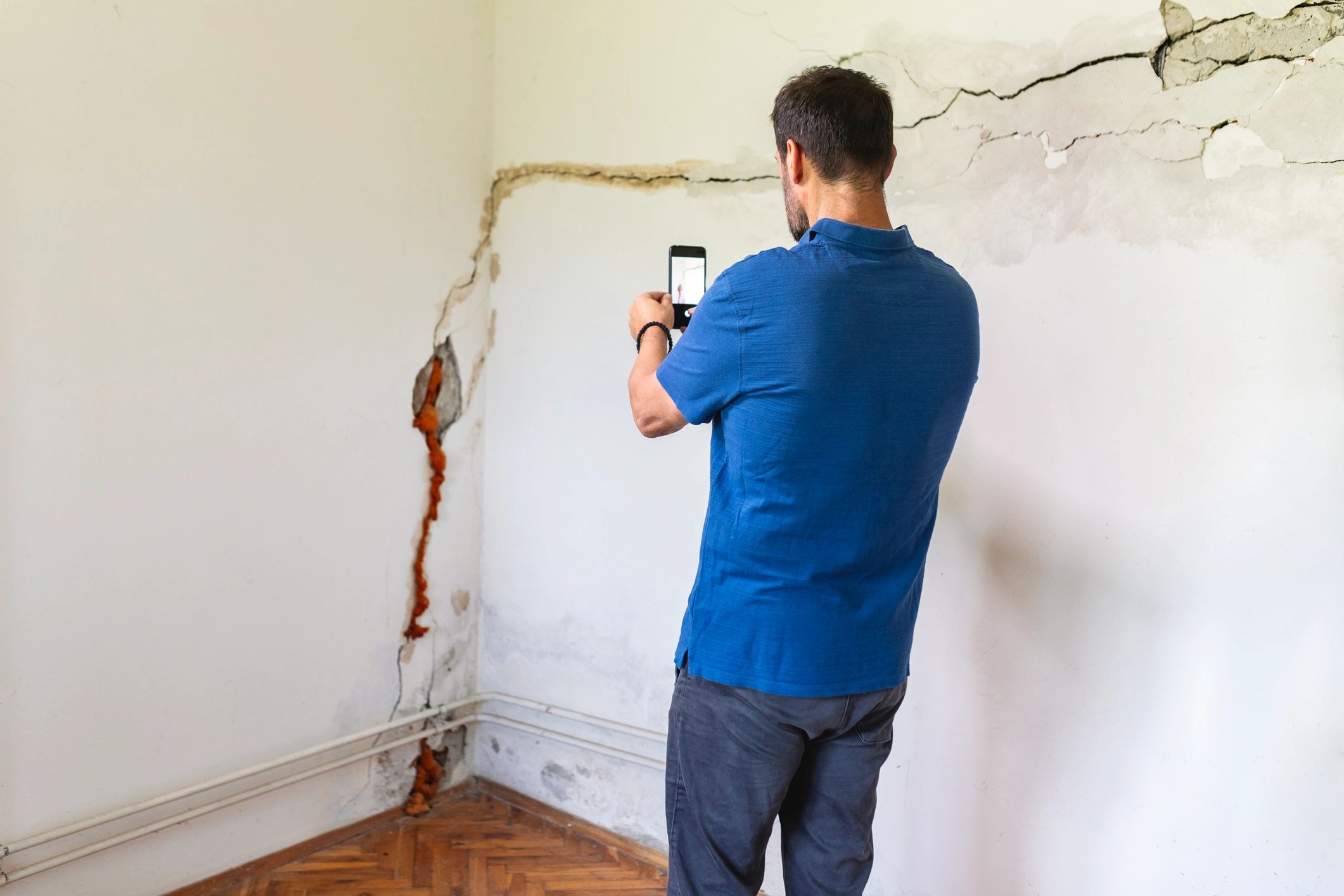 Technician assessing damage to a wall during an inspection